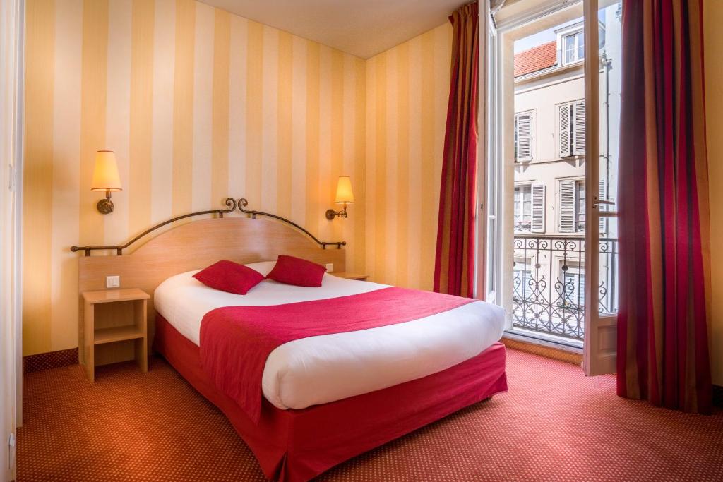 ein Hotelzimmer mit einem Bett und einem Fenster in der Unterkunft Hotel Delambre in Paris