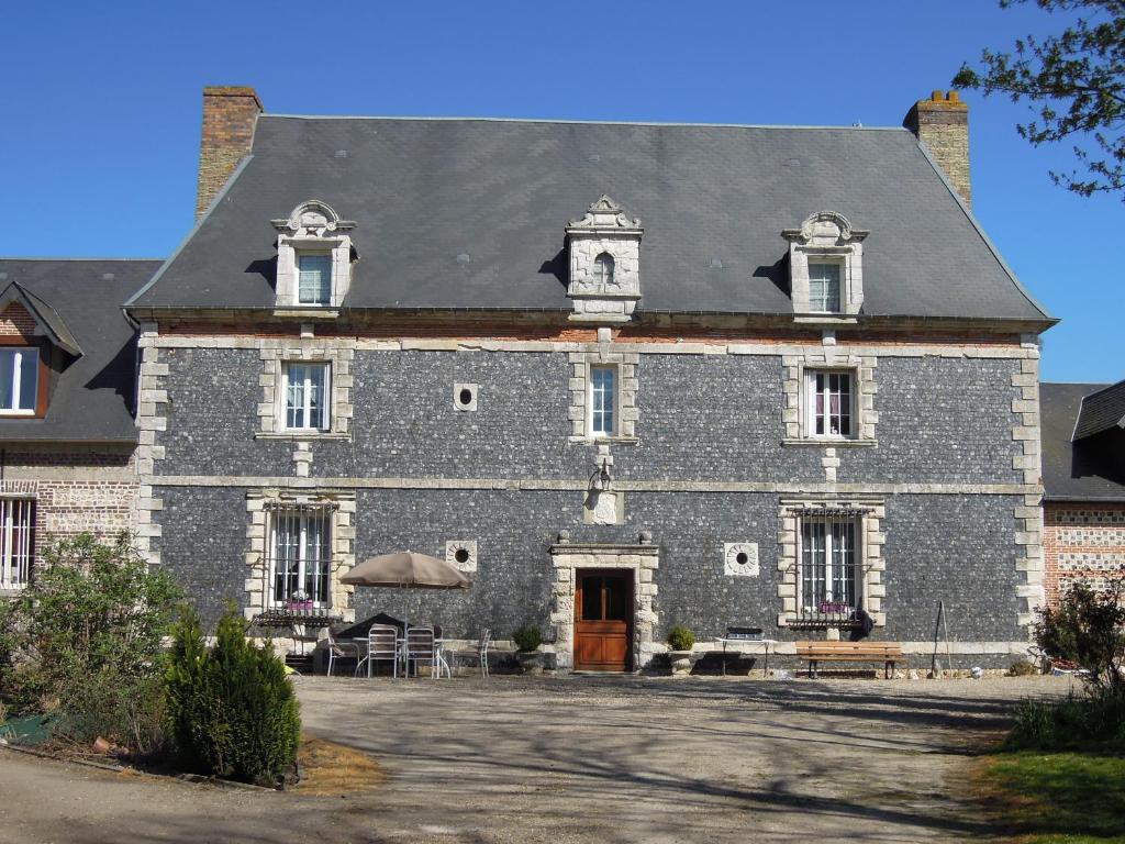 a large brick building with a clock tower on top at manoir de saint supplix in Octeville-sur-Mer