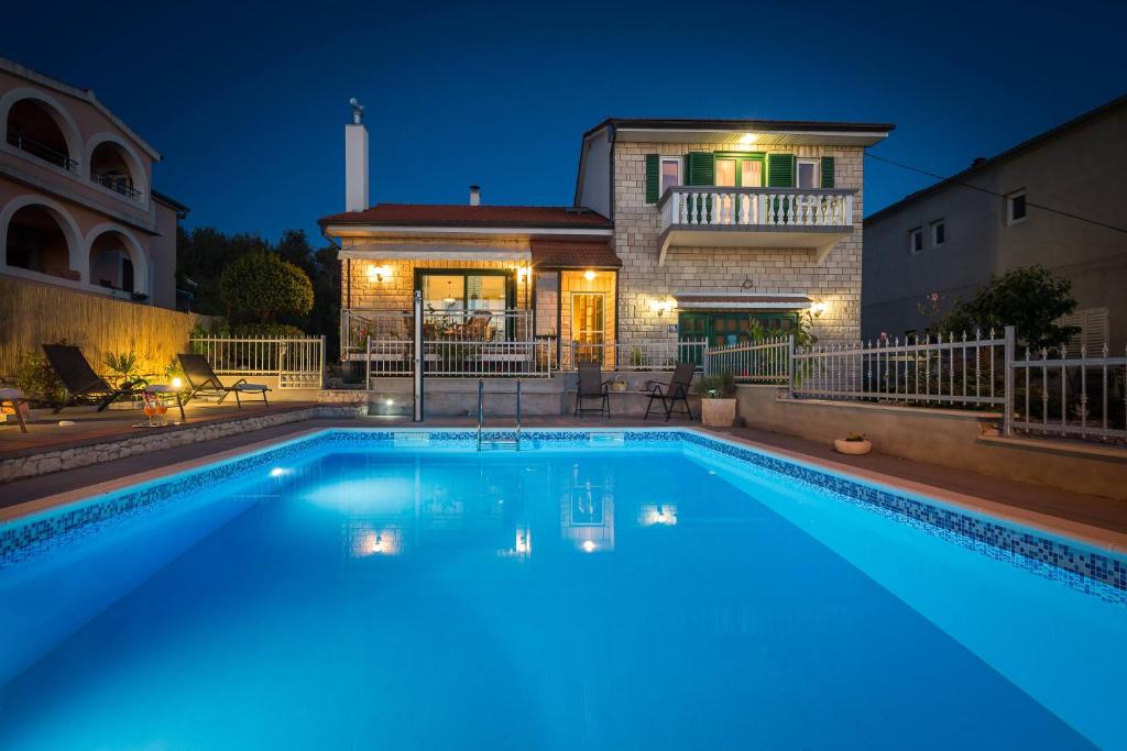 a swimming pool in front of a house at night at Villa Otavia in Šibenik