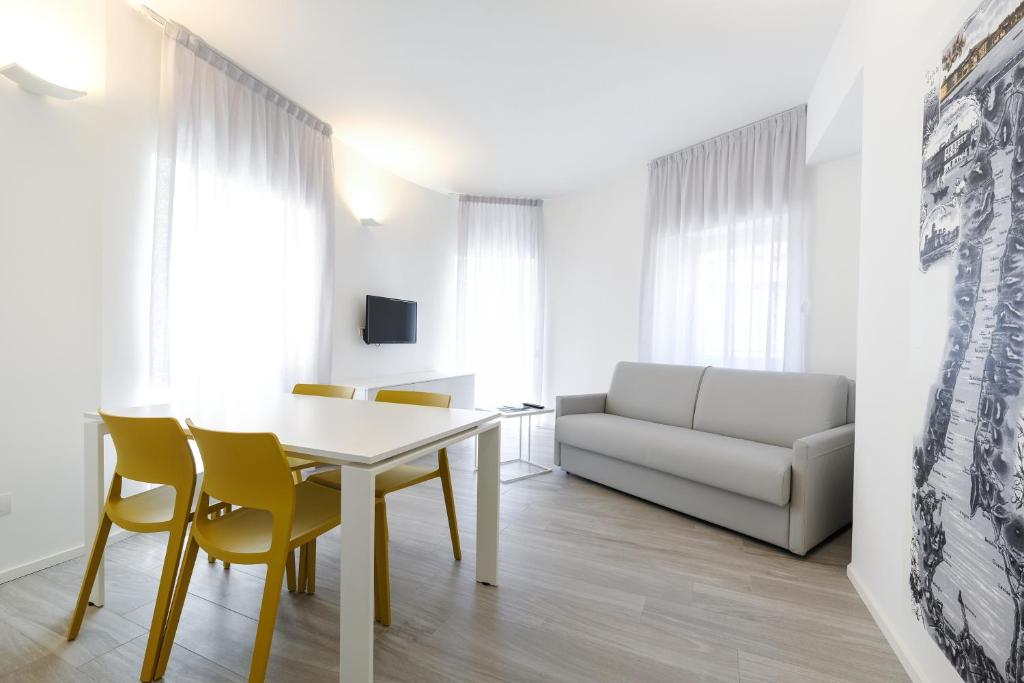 a living room with a table and chairs and a couch at Bertamini Apartments in Nago-Torbole