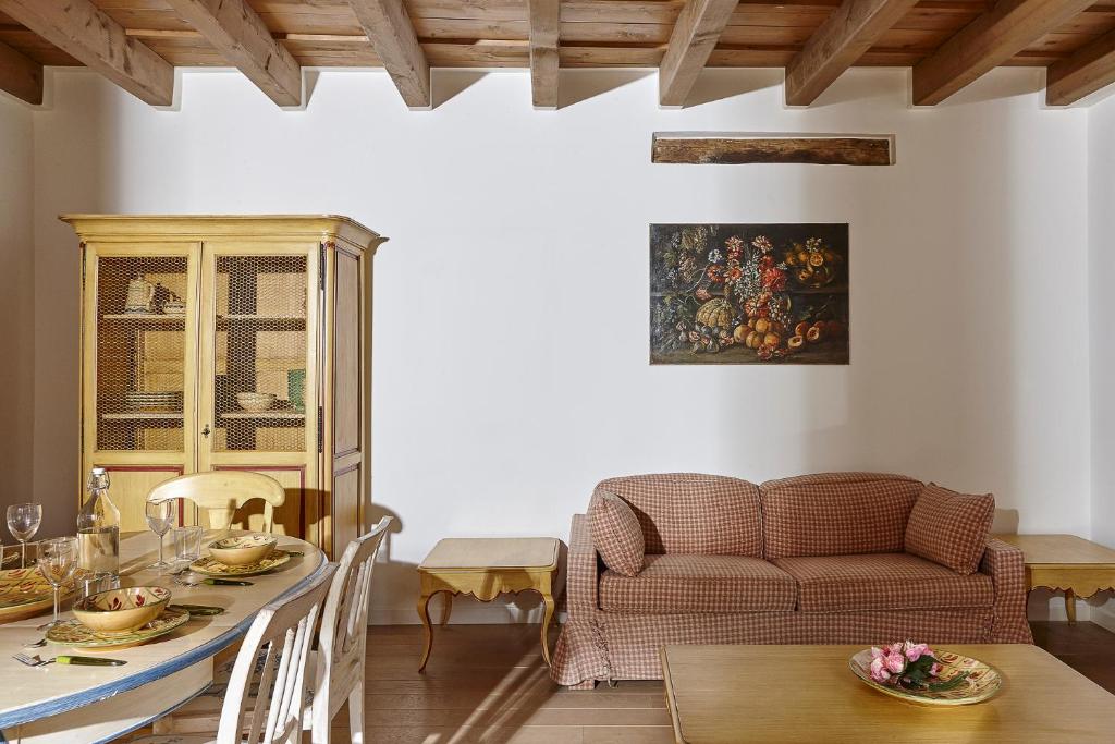 een woonkamer met een tafel en een bank bij JOIVY Charming Apt Centre of Como in Como