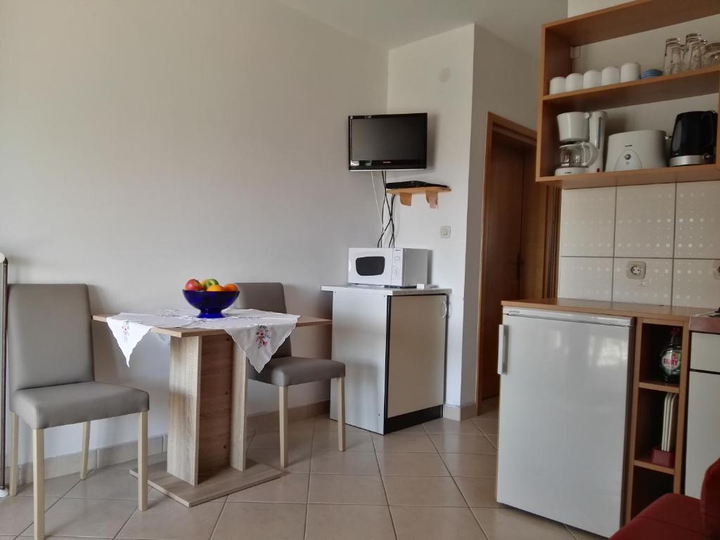 a kitchen with a table and chairs and a small table at Apartment Pezić in Krk