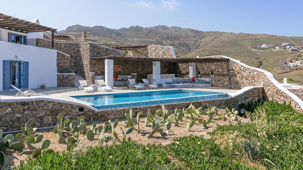 a villa with a swimming pool and a house at Mykonos Panormos Villas in Mykonos