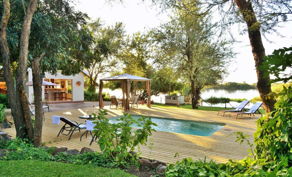 a wooden deck with a pool and a gazebo at River View Lodge in Kasane