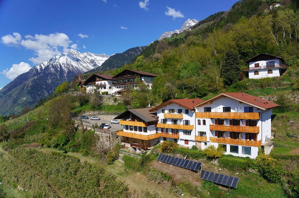 a group of buildings on a hill with mountains at Residence Vellauerhof in Lagundo