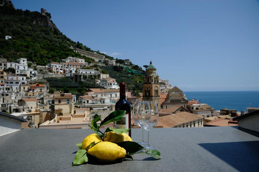 una bottiglia di vino e un bicchiere di pere su un cornicione di Appartamento Paradiso ad Amalfi