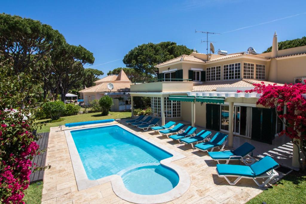 a villa with a swimming pool and lounge chairs at Villa Popa in Quarteira
