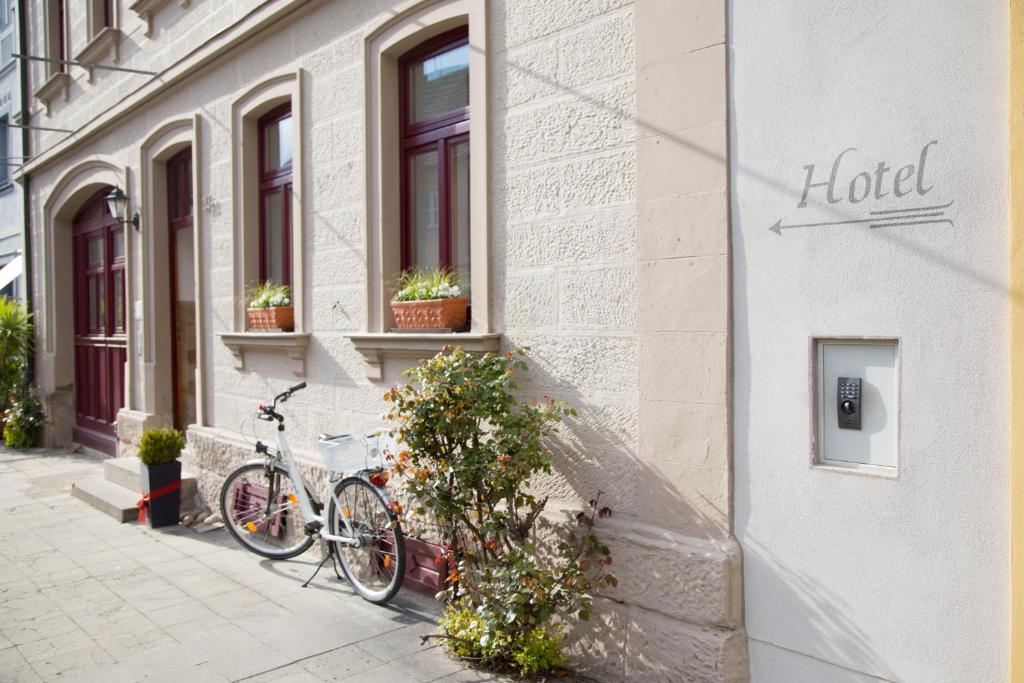 ein Fahrrad, das an der Seite eines Gebäudes geparkt ist in der Unterkunft Hotel Garni Zum Hirschen in Iphofen