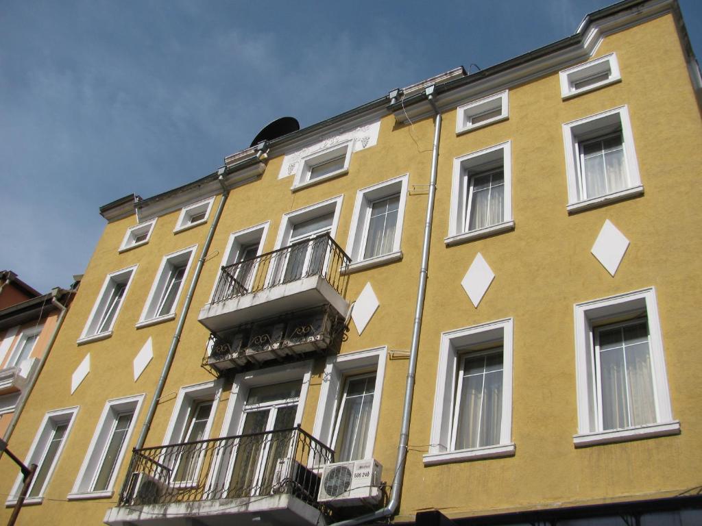 un edificio amarillo con balcones en un lateral en Apartments Iris69 en Varna