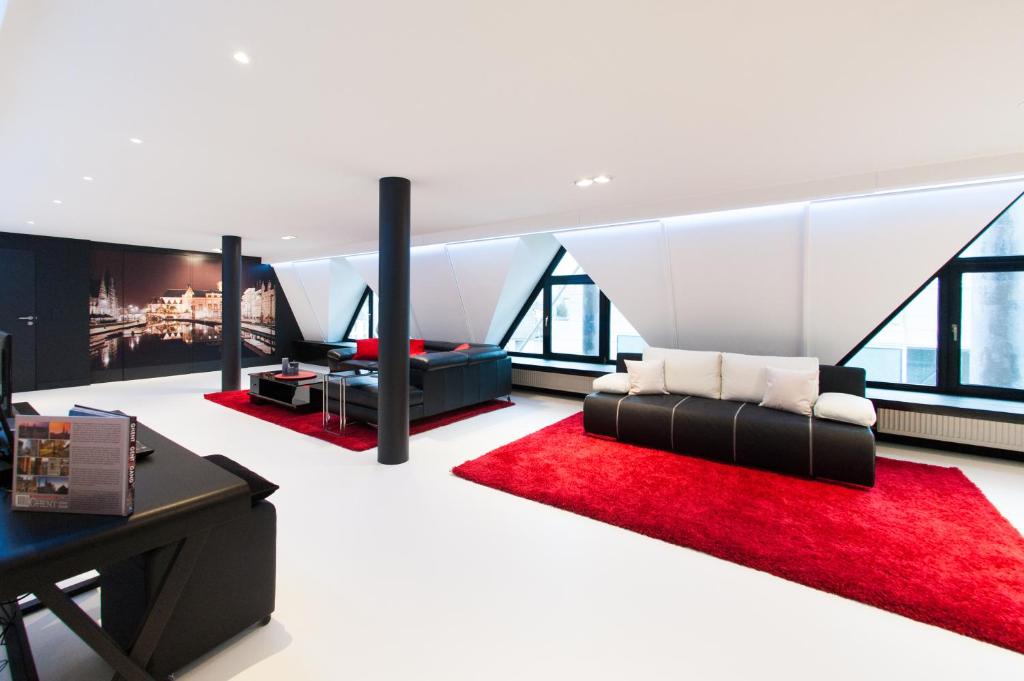 uma sala de estar com um sofá e um tapete vermelho em Lord of Ghent em Gante