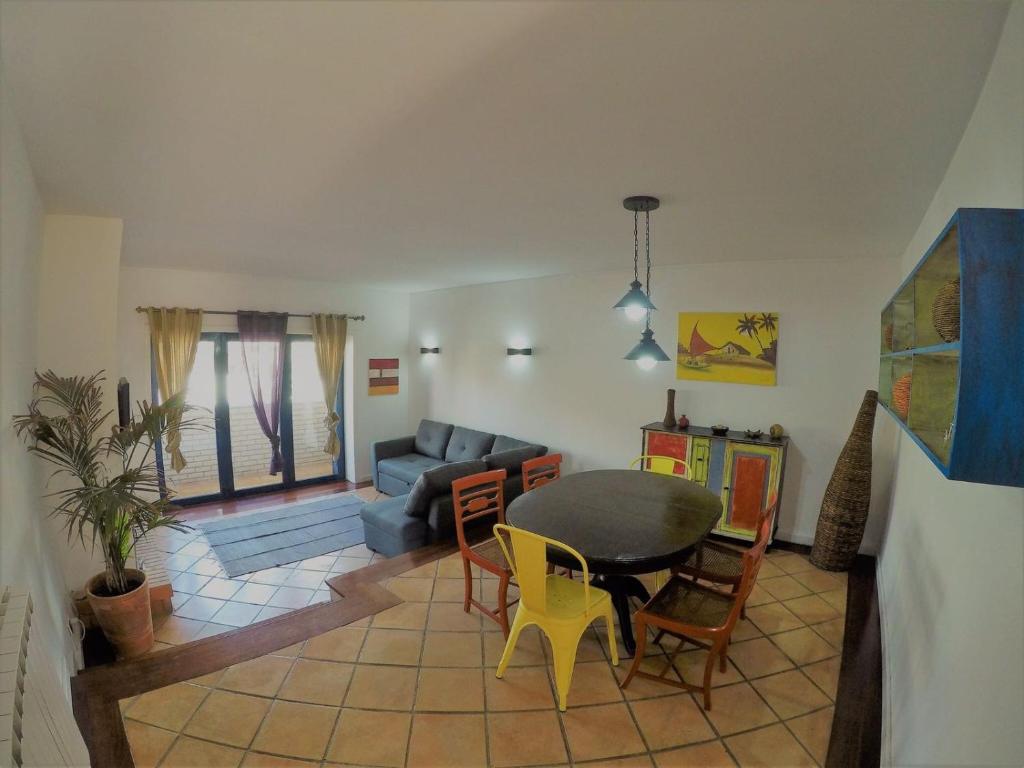 a living room with a table and chairs and a couch at Beach House in Madalena