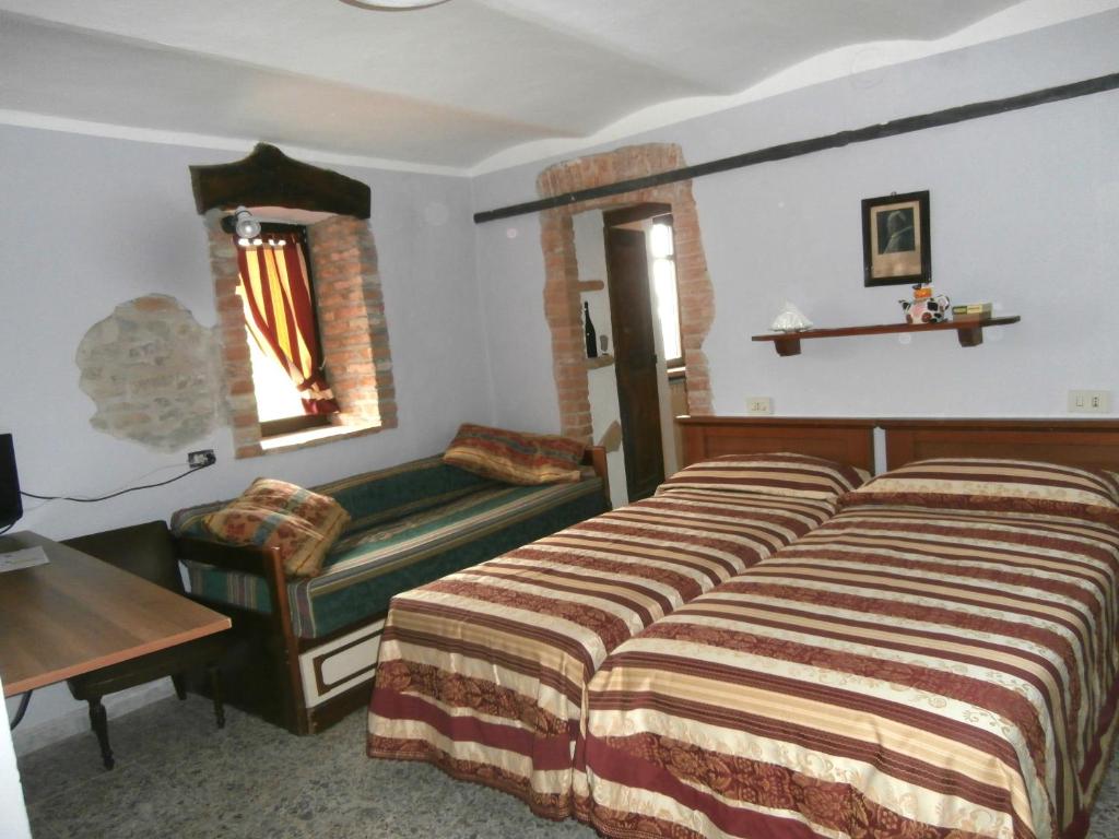 a hotel room with two beds and a bench at B&B Rumanot in Dogliani