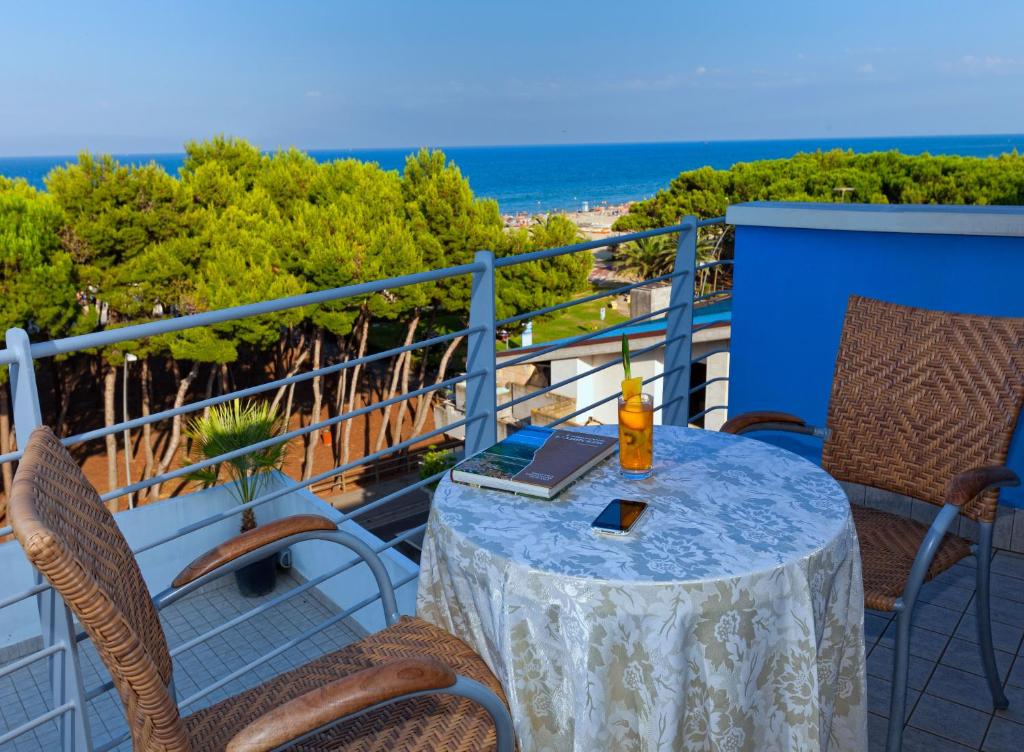 a table and chairs on a balcony with the beach at Hotel Antares in Alba Adriatica