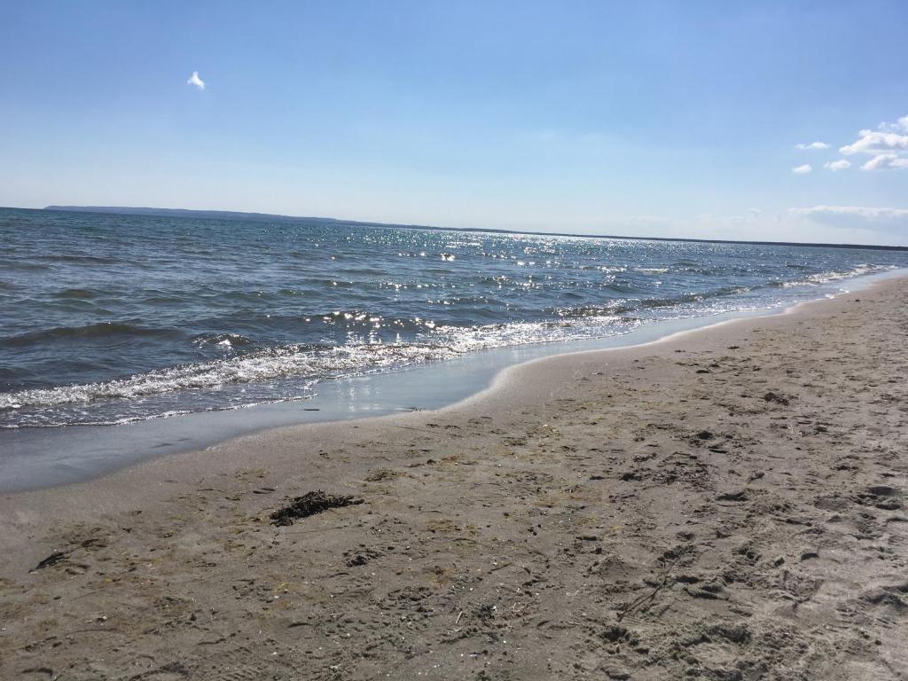 einen Sandstrand mit dem Ozean im Hintergrund in der Unterkunft Ferienwohnung Morgenrot in Juliusruh