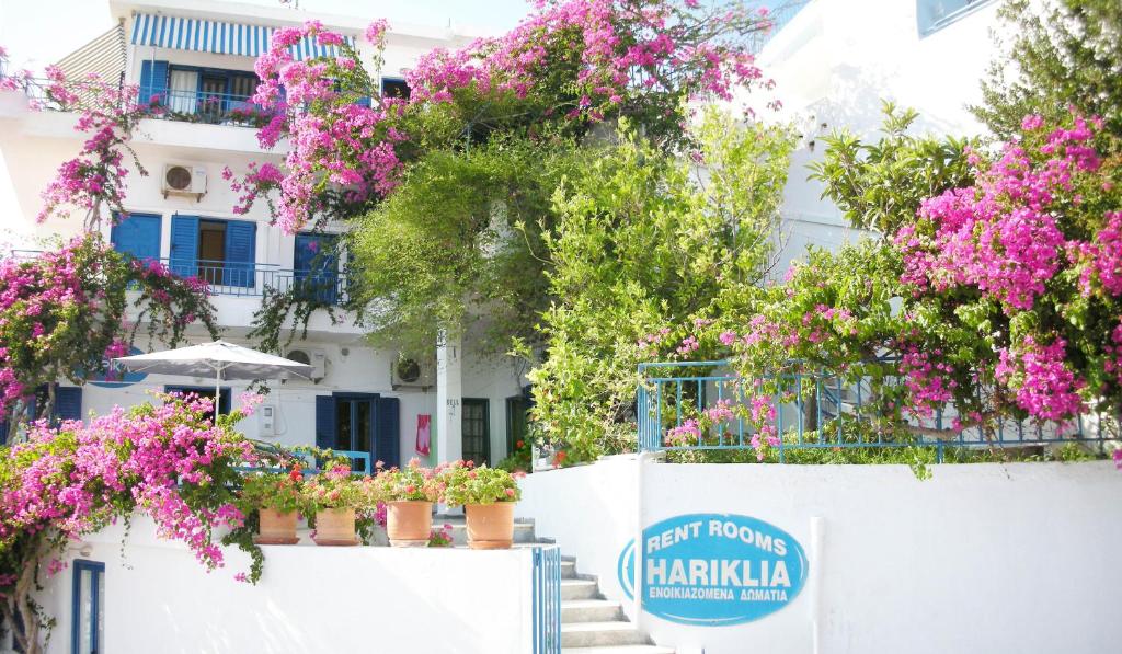 un bâtiment blanc avec des fleurs sur une clôture dans l'établissement Hotel Hariklia, à Agia Galini