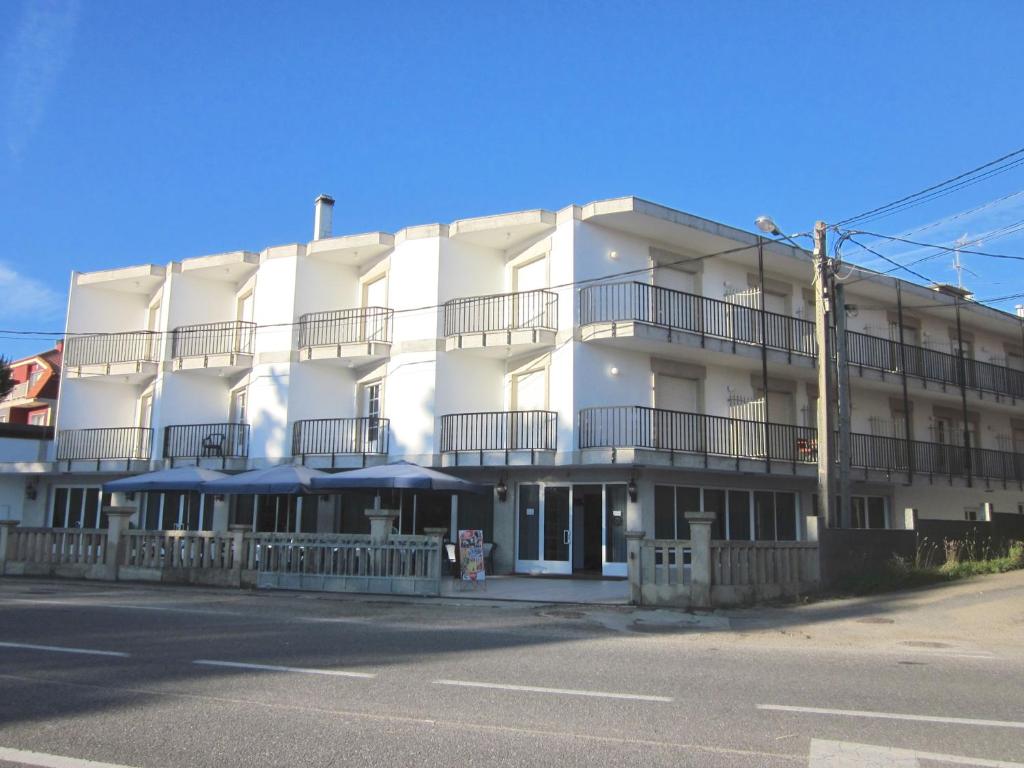 a white building with balconies on the side of the street at Hotel Sixto in Montalvo