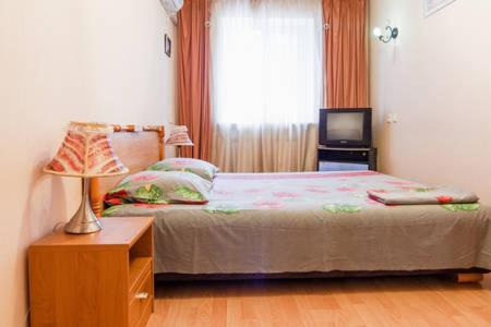 - une chambre avec un lit doté d'une lampe et d'une fenêtre dans l'établissement Apartment on Evreyskaya 42a, à Odessa