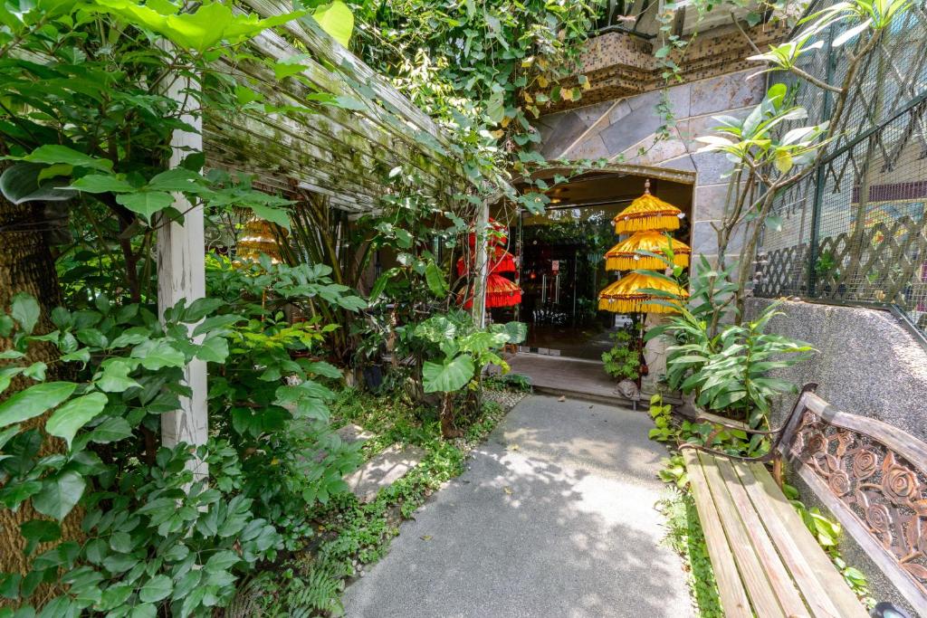 einen Garteneingang zu einem Gebäude mit einer Bank in der Unterkunft Bali House in Hualien