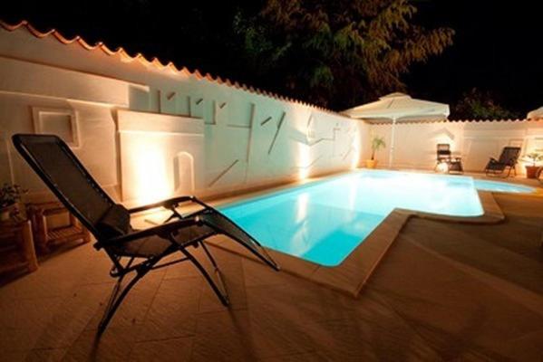 una sedia seduta accanto alla piscina di notte di Hotel Makin a Novigrad Istria
