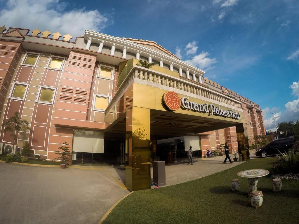 a large pink building with a sign on it at Butuan Grand Palace Hotel in Butuan