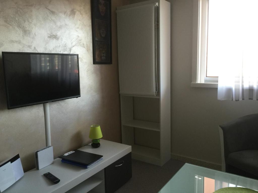 a living room with a tv and a desk with a lamp at Fréjus Studio in Fréjus