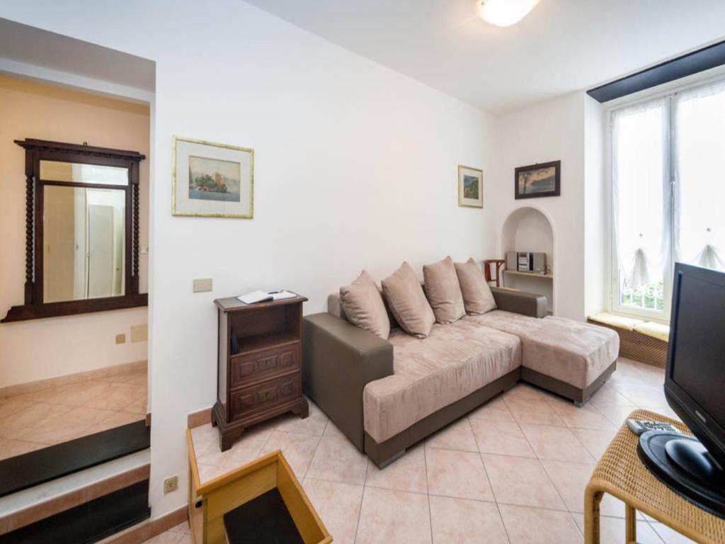 een woonkamer met een bank en een televisie bij Garibaldi Flexyrent Apartment in Rapallo