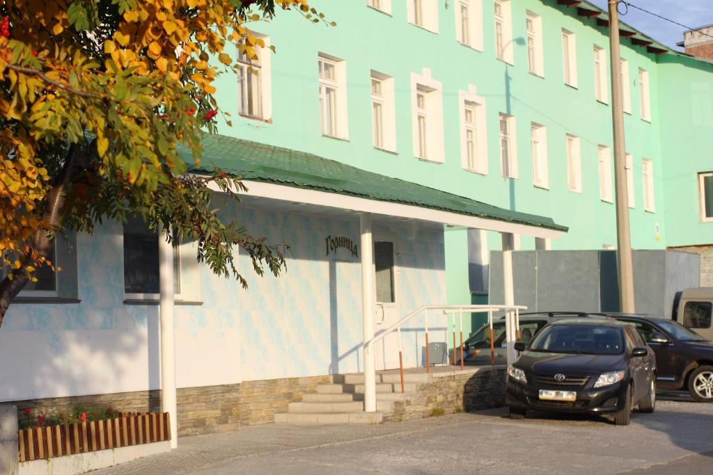 un coche aparcado frente a un edificio en Gornitsa Hotel, en Kirovsk