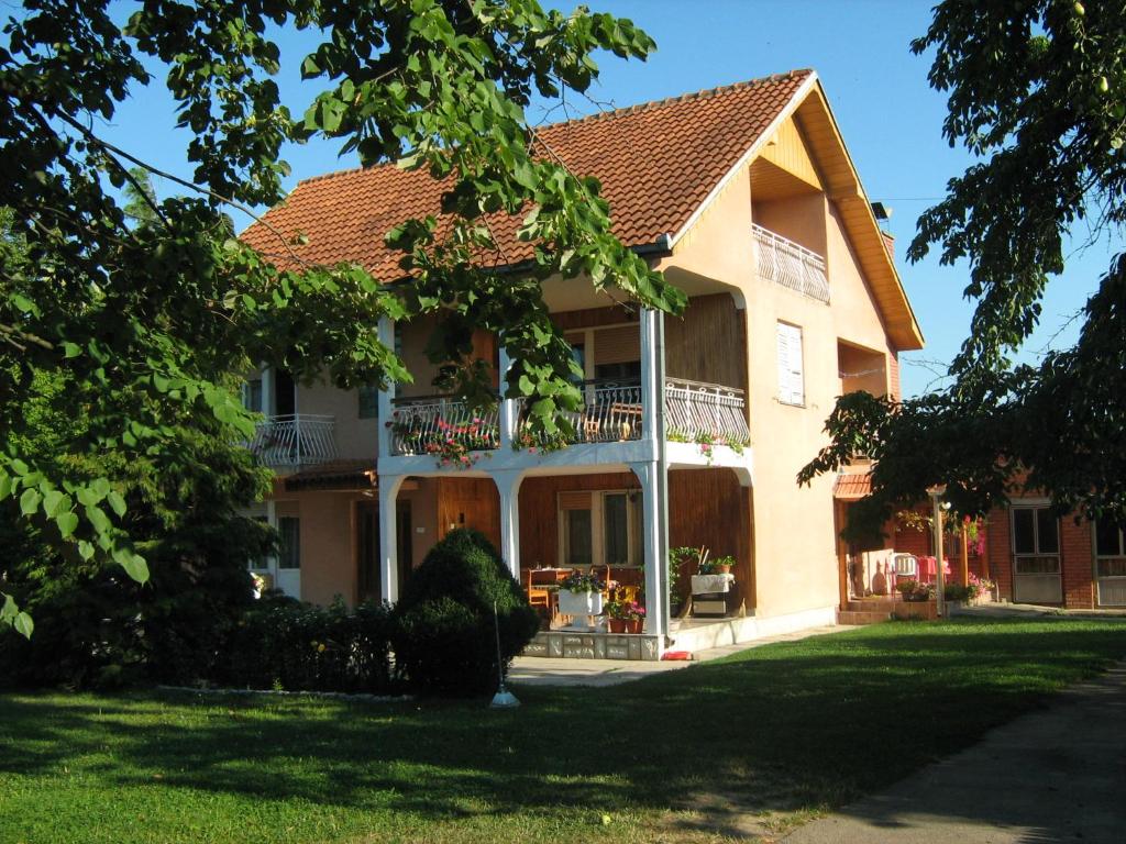 een groot huis met een balkon en een tuin bij Apartments Domaćinstvo Nikolić in Valjevo