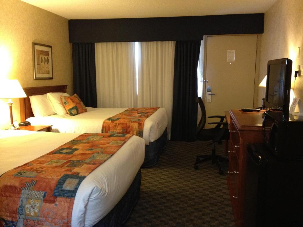 Postel nebo postele na pokoji v ubytování North Vancouver Hotel