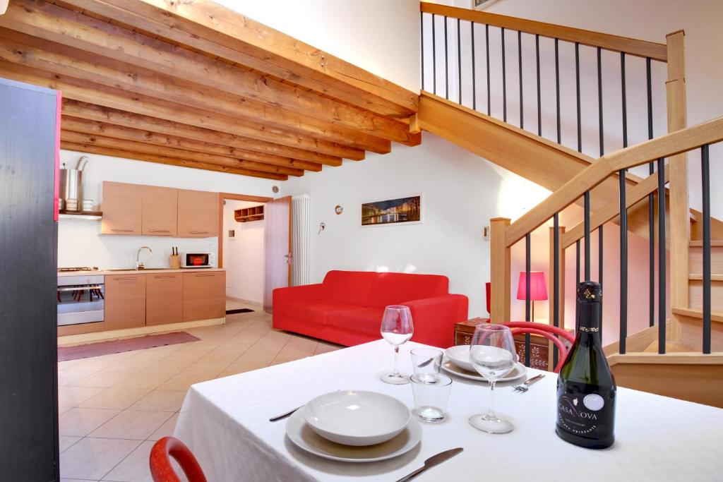 comedor con mesa y sofá rojo en Lagoon Apartment, en Venecia