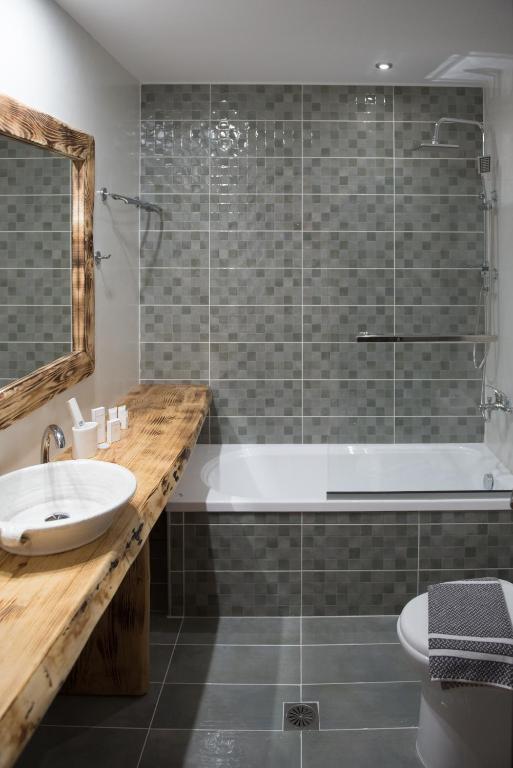 a bathroom with a tub and a sink and a mirror at Archontiko Liamas in Stavros