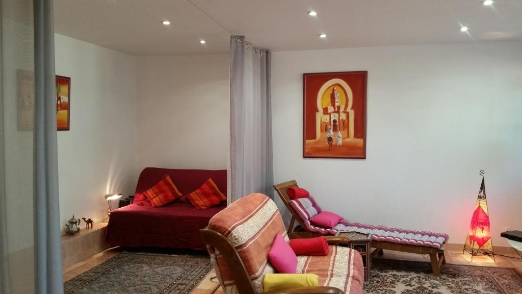 a living room with a bed and a chair at Chambre Avec Jardin Pierre Curie in Bry-sur-Marne