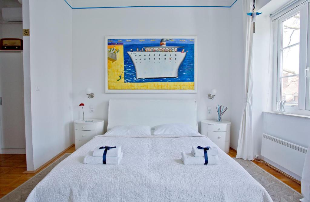a white bedroom with a bed with two towels on it at Rooms Zagreb 17 in Zagreb