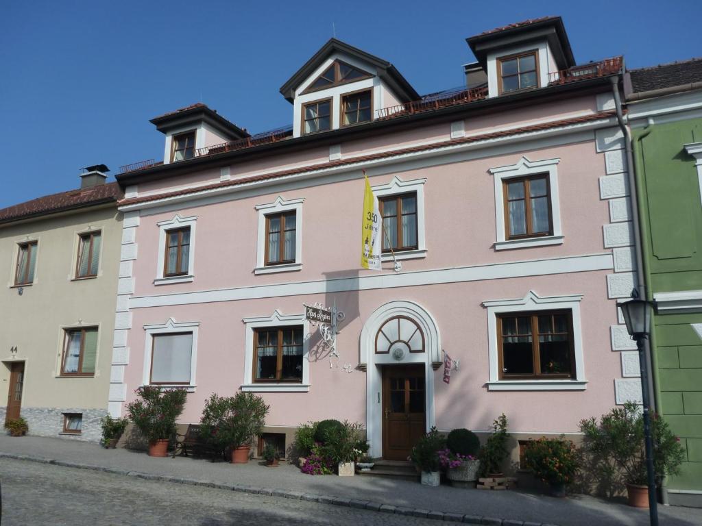 ein rosafarbenes Gebäude an der Straßenseite in der Unterkunft Haus Regina in Maria Taferl