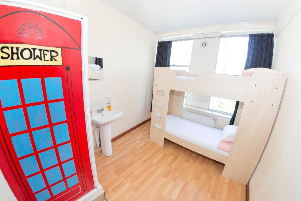 a room with a red phone booth and a bunk bed at Kensal Green Backpackers in London