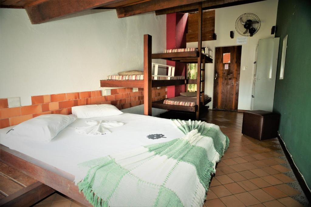 a bedroom with a large bed and a staircase at Laranjeiras Hostel in Salvador
