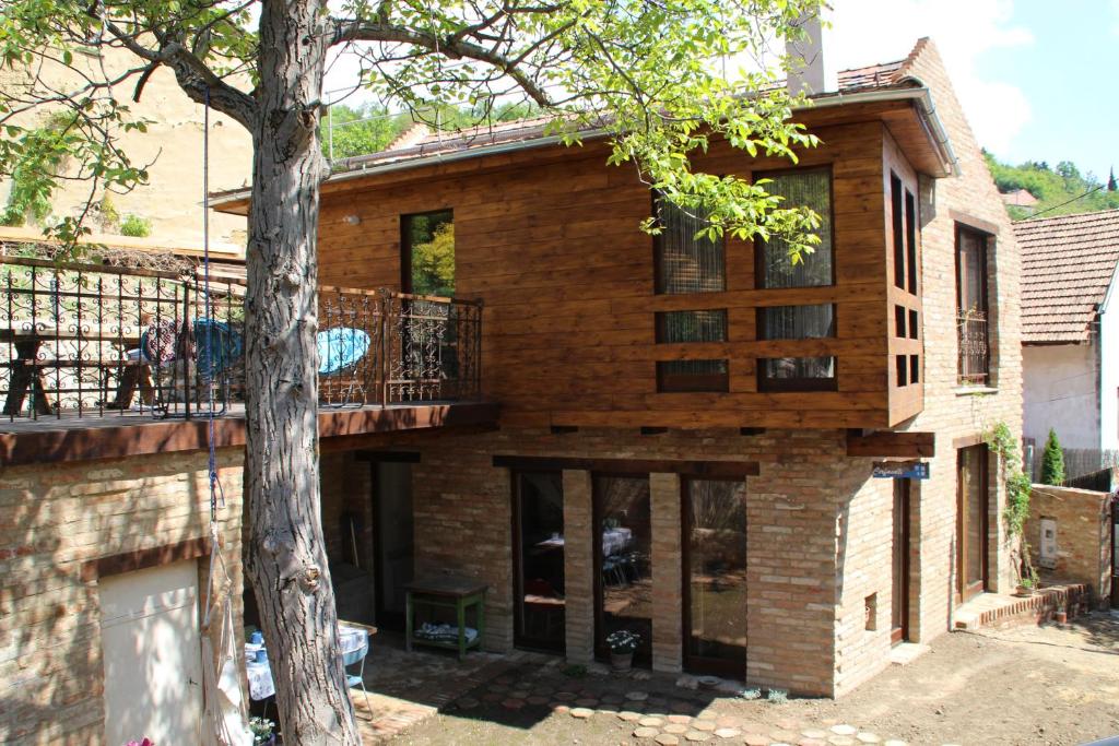 佩奇的住宿－Cirfandli Vendégház，带阳台和树的木屋