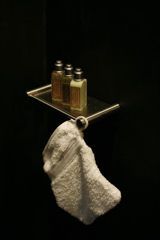 a metal towel holder with two bottles of medicine at Les 4 étoiles in Montpellier