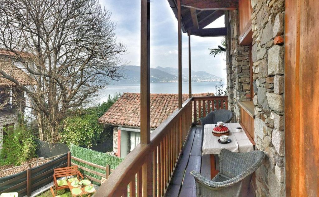 einen Balkon mit einem Tisch und Stühlen sowie Blick auf das Wasser in der Unterkunft Coco in Baveno