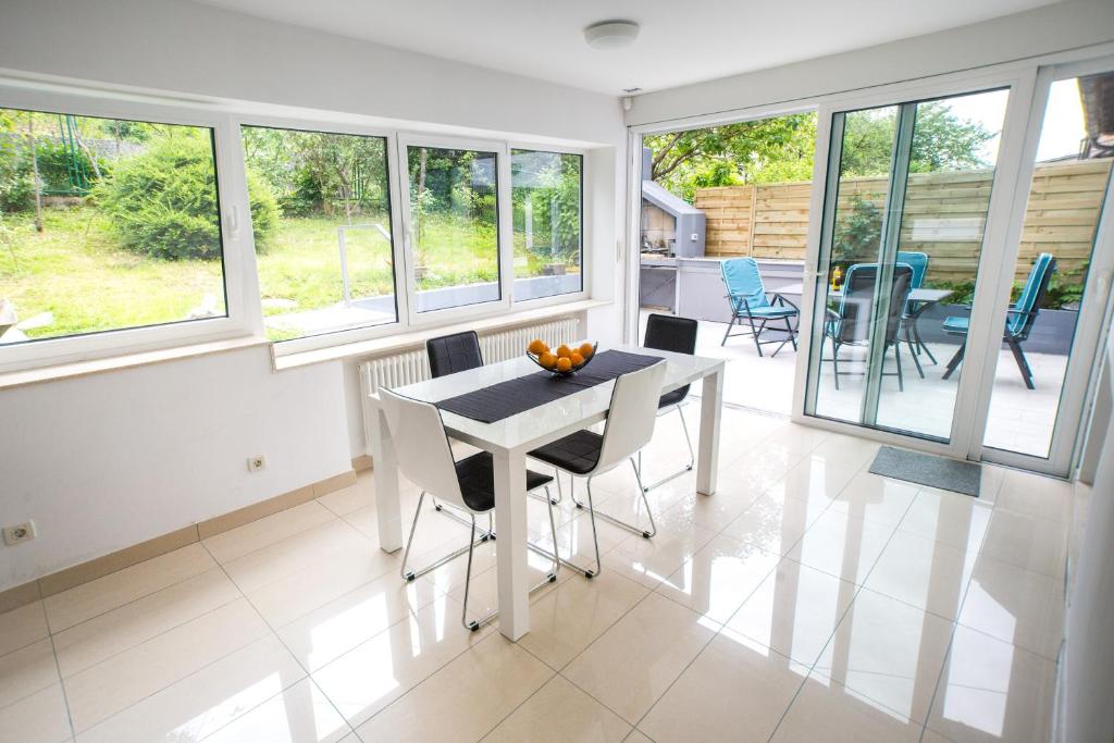 een eetkamer met een tafel, stoelen en ramen bij Apartment Jasna in Zagreb