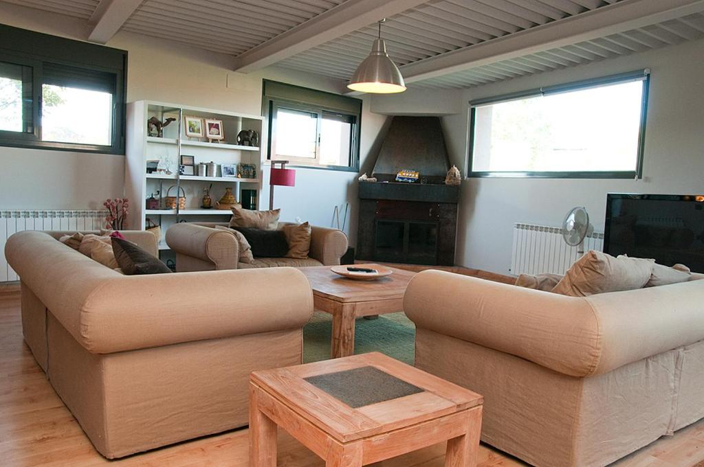 sala de estar con 2 sofás y TV en Casa Ruiz, en Ayerbe