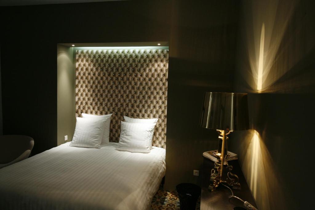 a bedroom with a bed with a headboard and a lamp at Les 4 étoiles in Montpellier