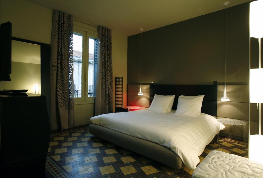 a bedroom with a large white bed and a window at Les 4 étoiles in Montpellier