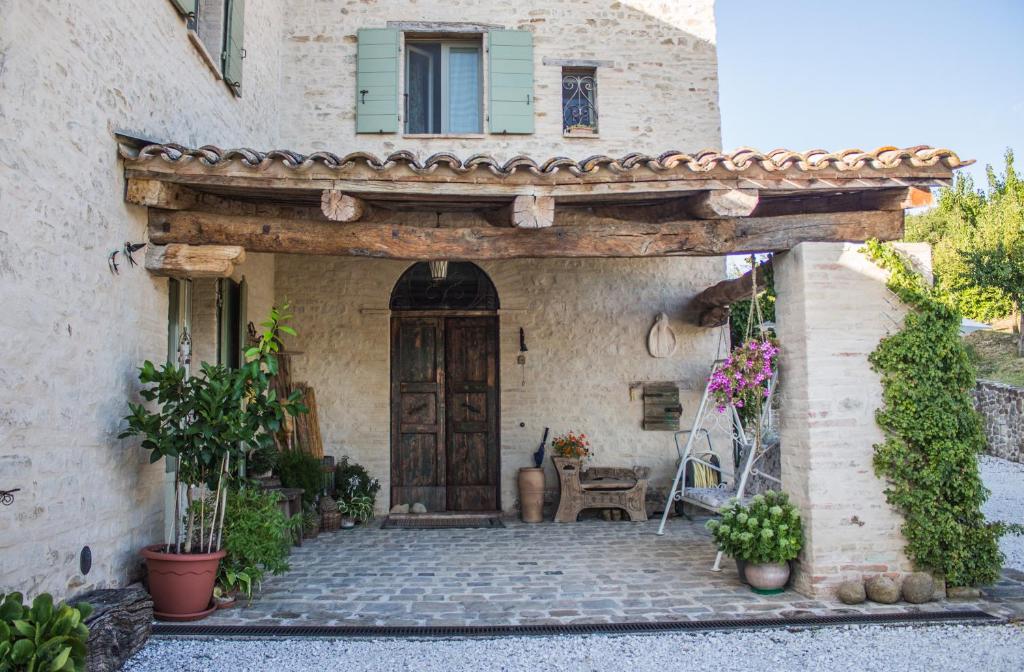 een toegang tot een huis met een houten deur bij Poggio Dei Prugnoli in Tavoleto