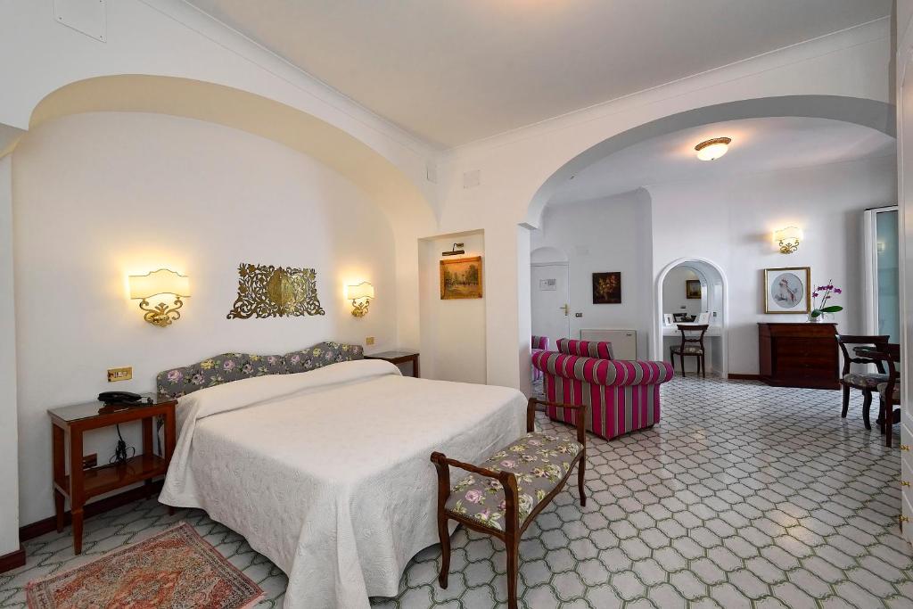 a bedroom with a bed and a table and chairs at Hotel Belvedere in Conca dei Marini