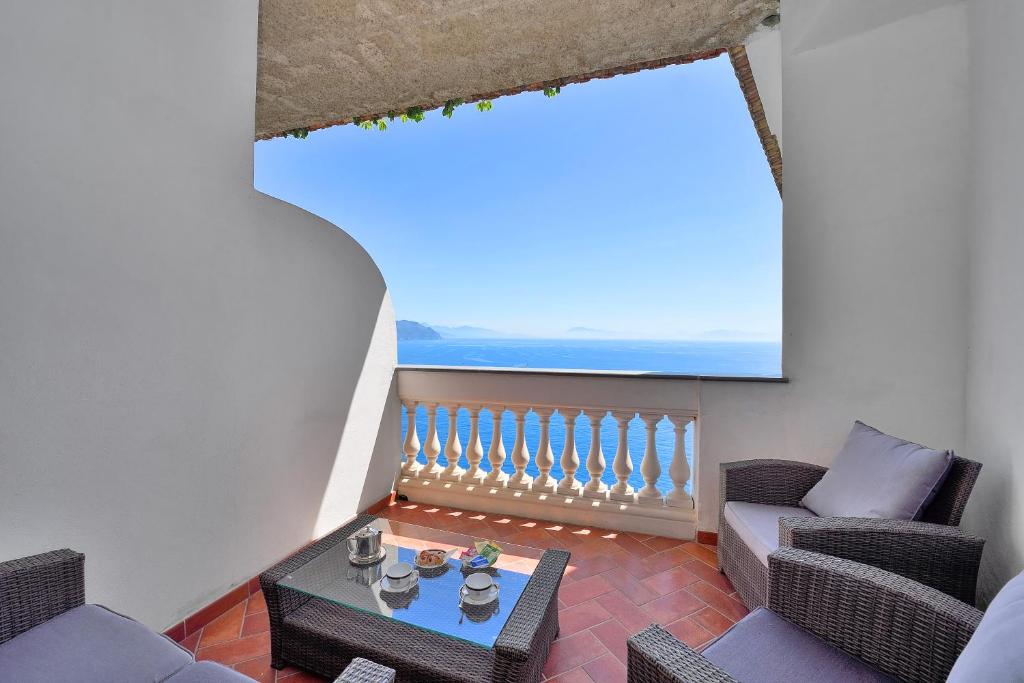 a living room with a table and chairs and a large window at Hotel Belvedere in Conca dei Marini
