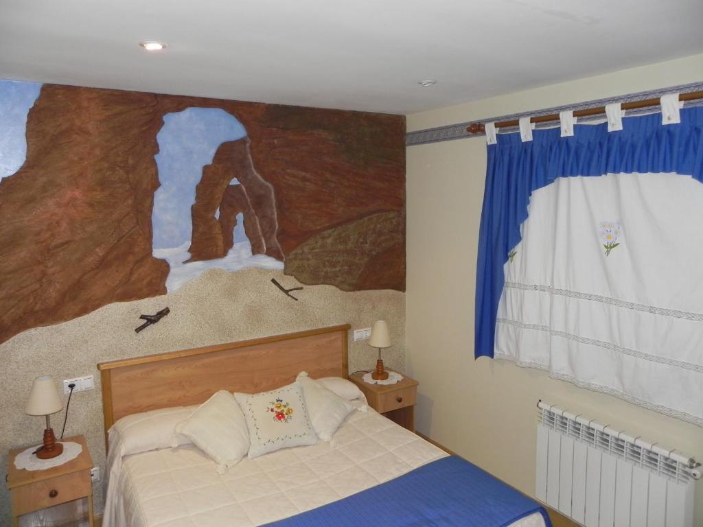 a bedroom with a large painting above a bed at O Lar de Carmiña in Devesa
