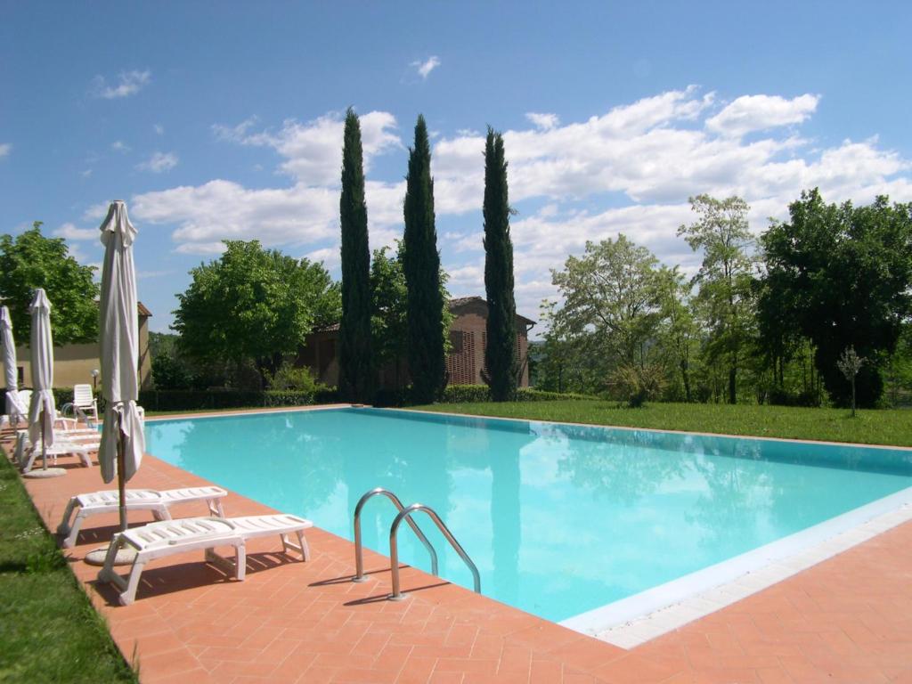 una grande piscina con sedie e ombrelloni di Appartamenti Avanella a 150 mt dalla piscina 150 mt from swimming pool a Certaldo