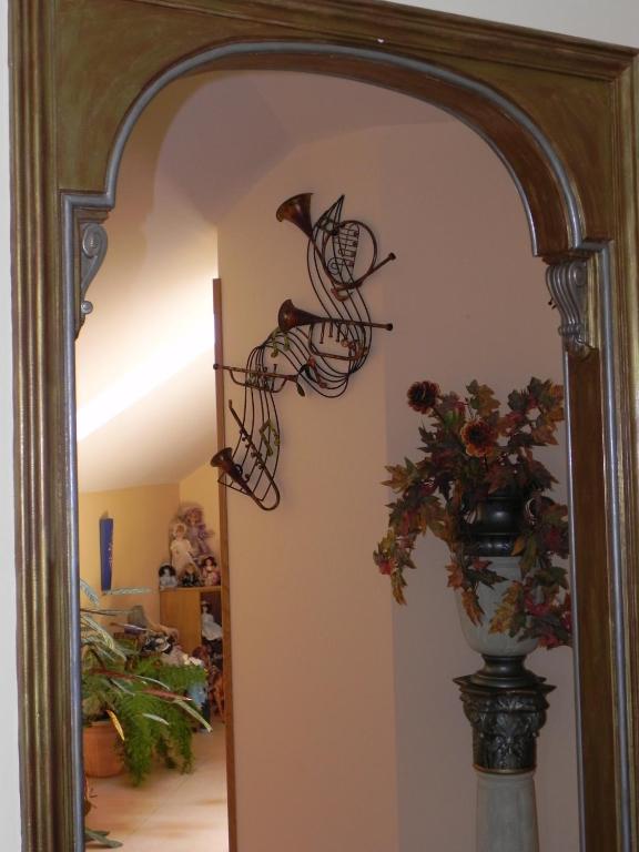 a mirror in a room with a vase of flowers at O Lar de Carmiña in Devesa