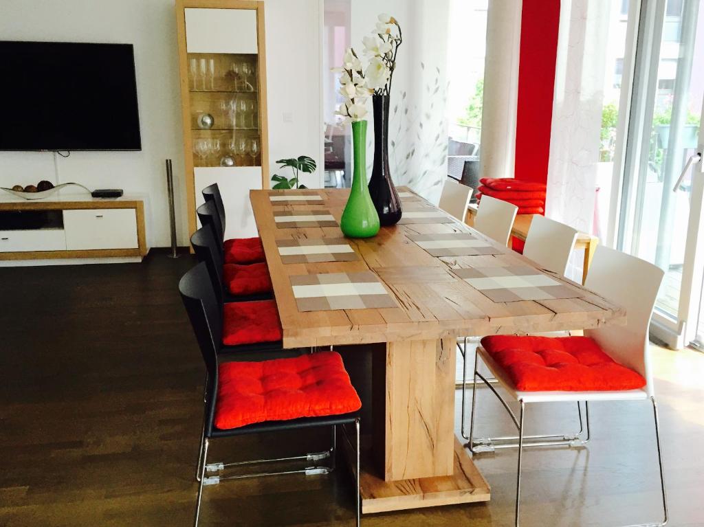 a dining room table with chairs and a vase with flowers at Rheinblick Riverview Luxury in Konstanz